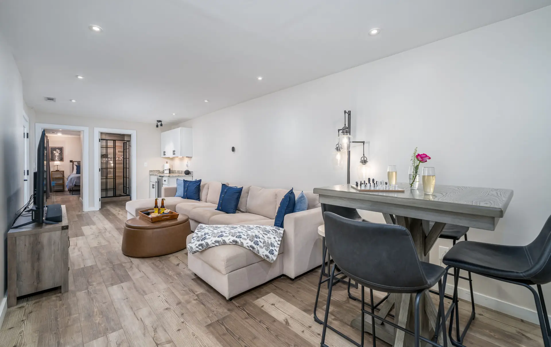 Once down the stairs, you will discover our movie room with a 65" Smart TV, wetbar, and cocktail table. Game on